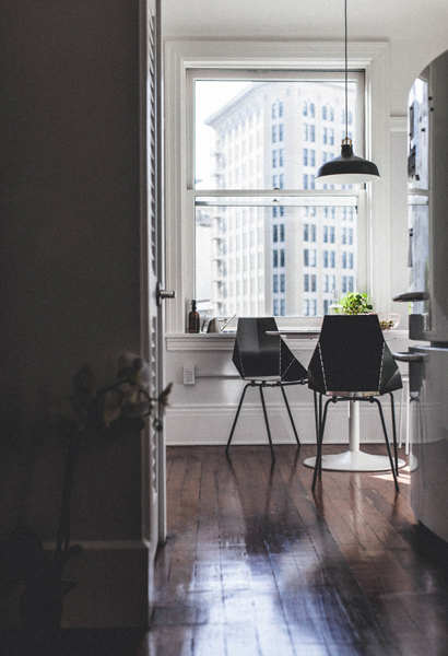 modern dinning room with black and white furniture and a large window with a building view. modern windows and doors. st catharines.